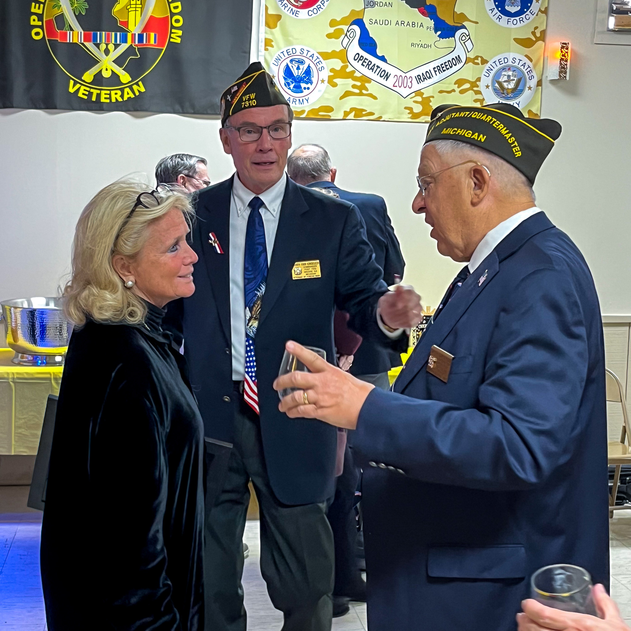 Rep. Dingell speaks with veterans at WWII veteran's 100th birthday celebration.