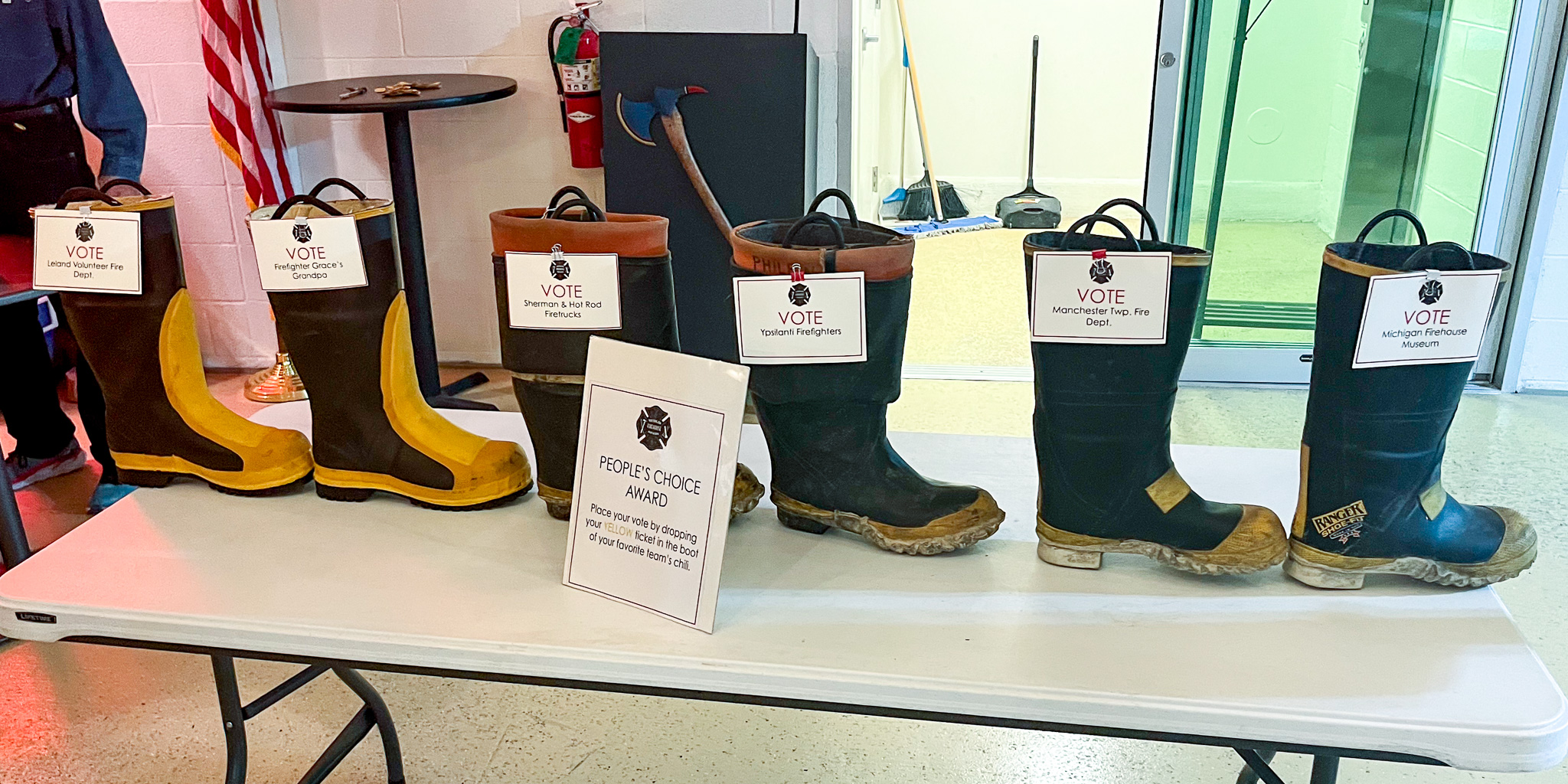 Firefighter boots on table used as ballot boxes for chili cook-off voting.