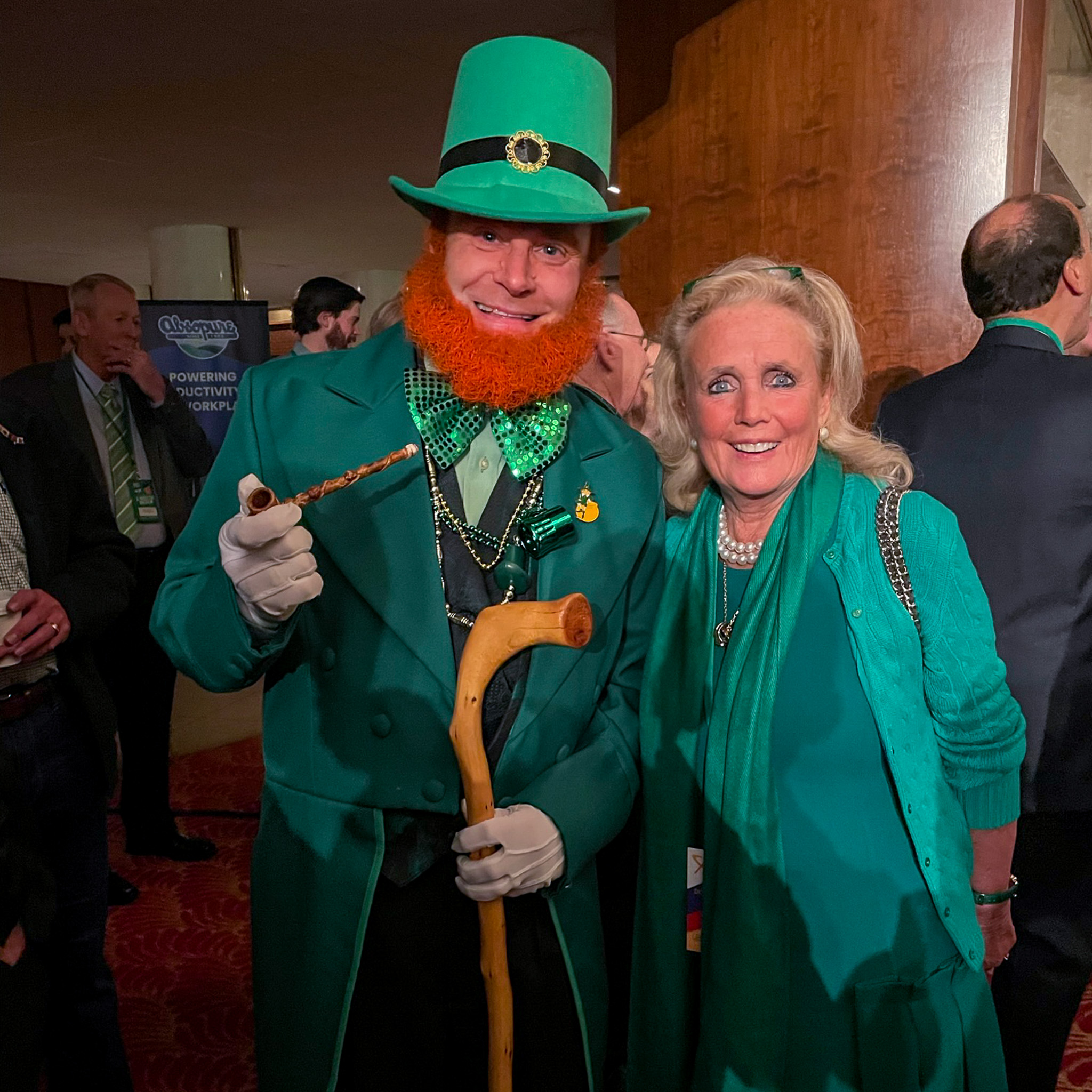 Rep. Dingell poses with person dressed in leprechaun costume at Paul W. Smith St. Patrick's Day Breakfast.